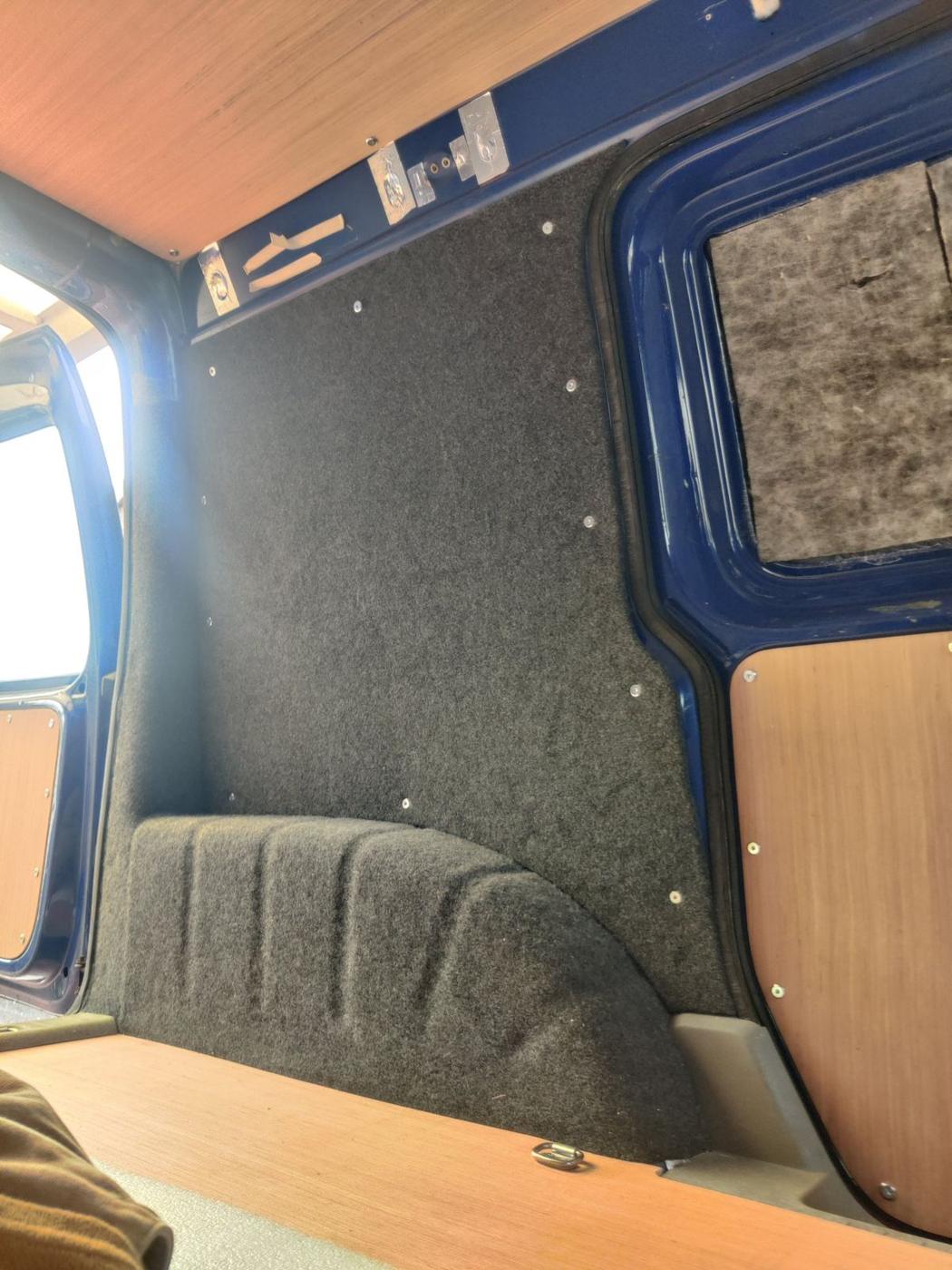 Carpet-lined van wall with insulation and ply panels